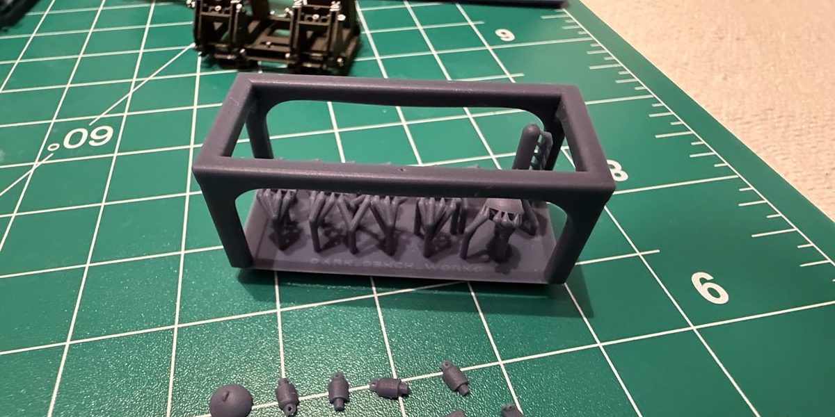 Resin parts in a print cage on a cutting mat