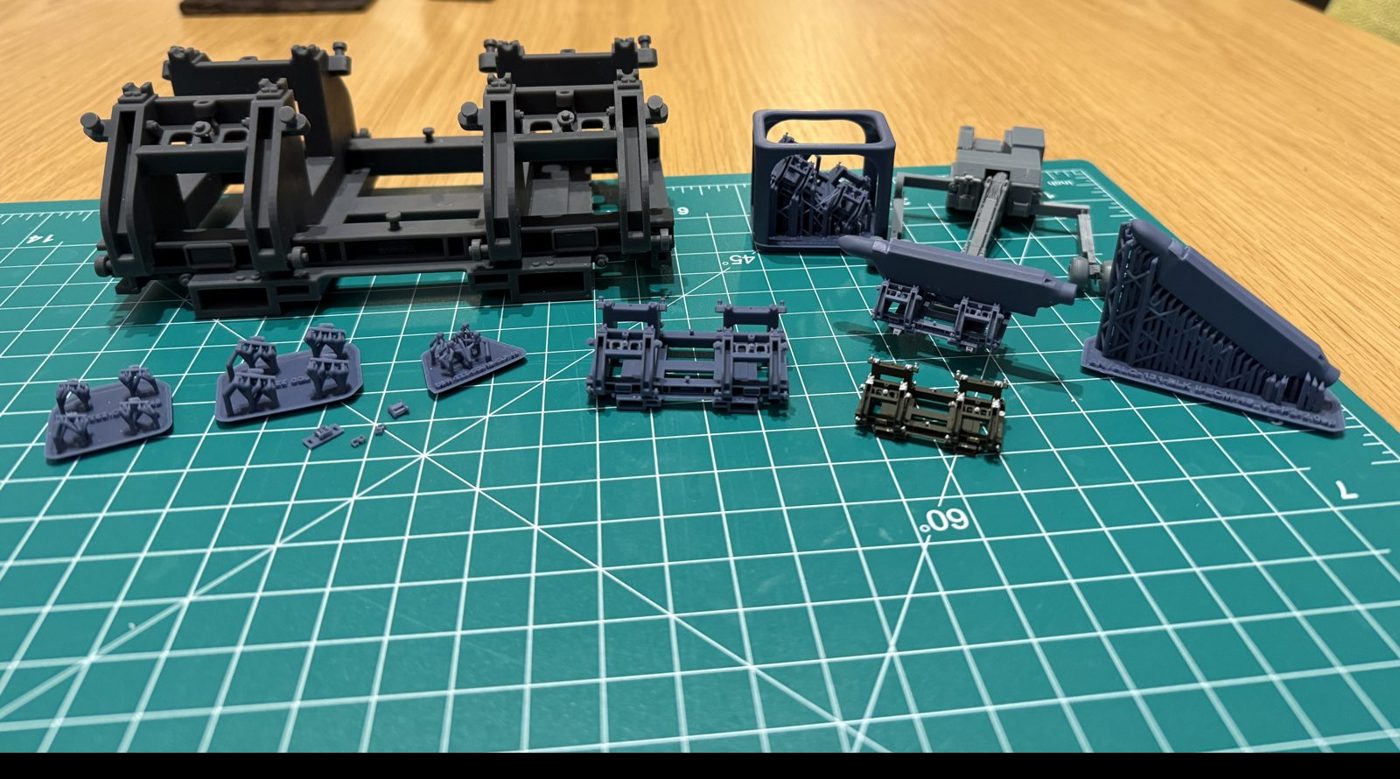 1/48 ECM pod loading cradle, ratchet straps, C-trap clips and pod on a cutting mat, with a Reskit MHU-83 jammer